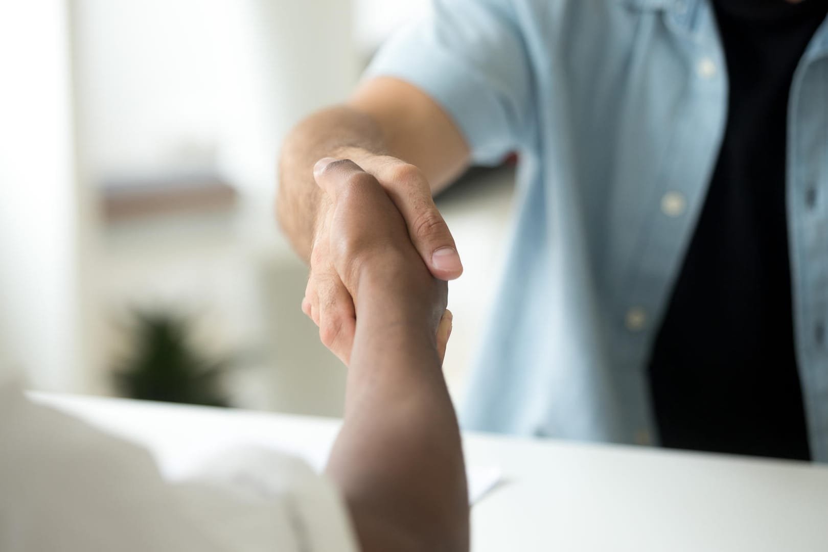 Zwei Männer geben sich die Hand: Vermeiden Sie Kontakt auch bei der Begrüßung. Zwei Männer geben sich die Hand: Vermeiden Sie Kontakt auch bei der Begrüßung.