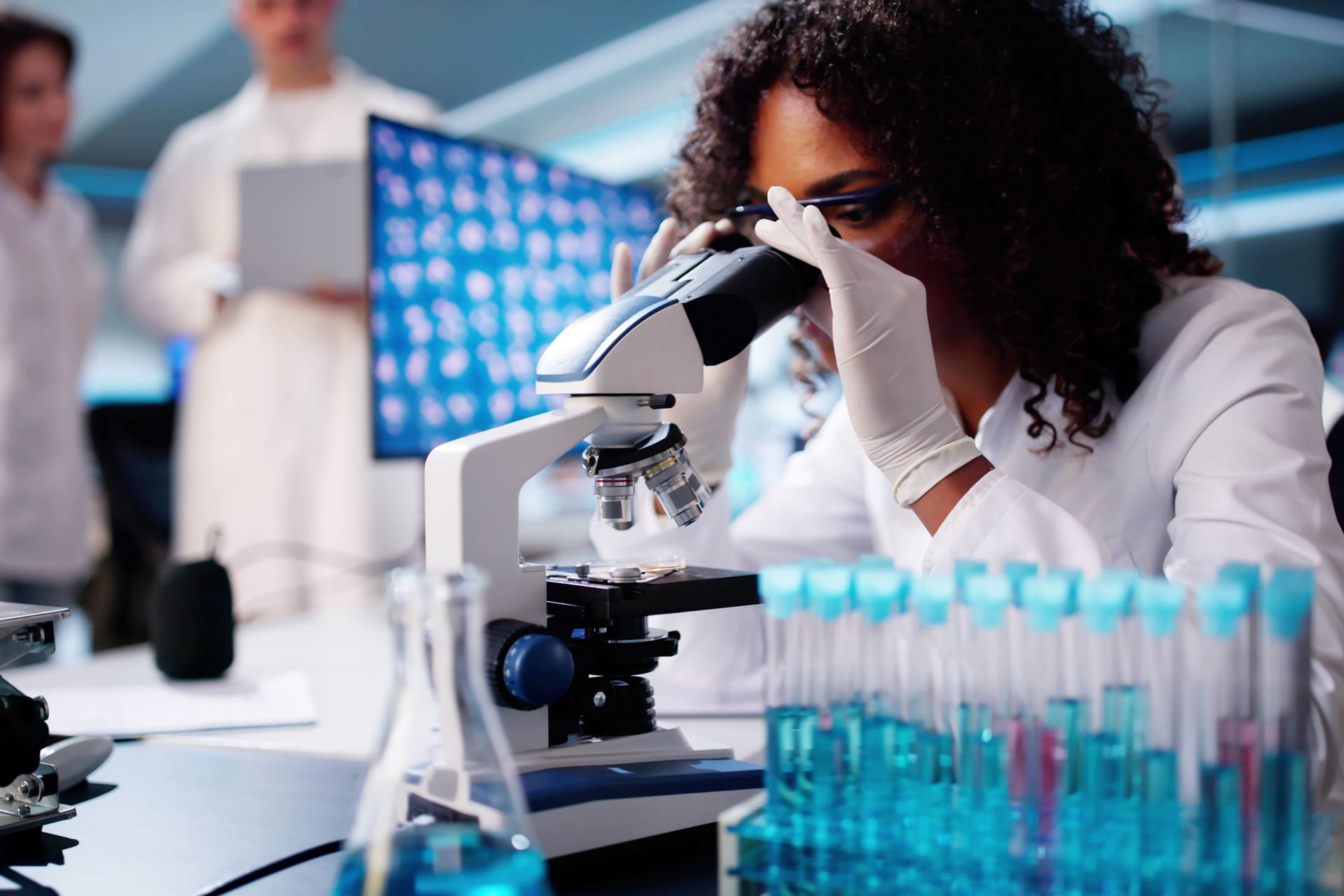 Wissenschaftlerin schaut durch ein Mikroskop.